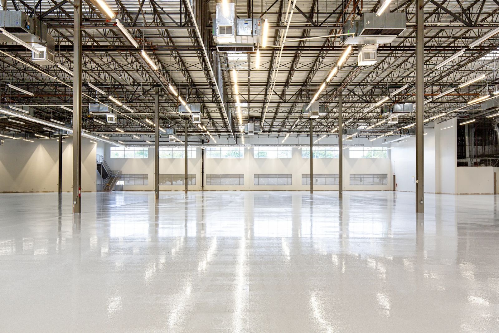 Revestimento epóxi industrial com acabamento espelhado em galpão — referência visual